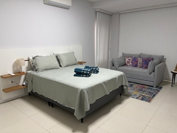 Cama tamaño queen, aire acondicionado, sofá cama, televisor inteligente de 50 pulgadas, internet, persianas opacas y balcón.