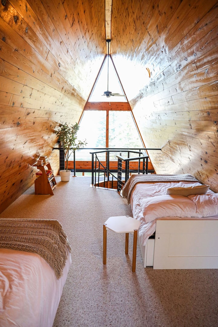 Loftová spálňa s dvoma výsuvnými posteľami – na tejto fotografii sú zobrazené ako dve samostatné postele, ale každú z nich je možné vytiahnuť a stať sa plnohodnotnou posteľou. V podkroví nájdete aj niekoľko hier a balíček kariet.