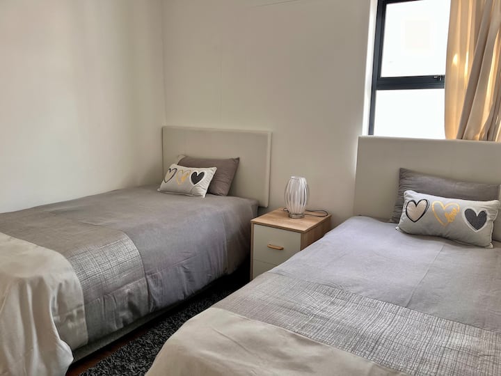 Segundo quarto com duas camas de solteiro, ideal para crianças, amigos ou hóspedes adicionais.