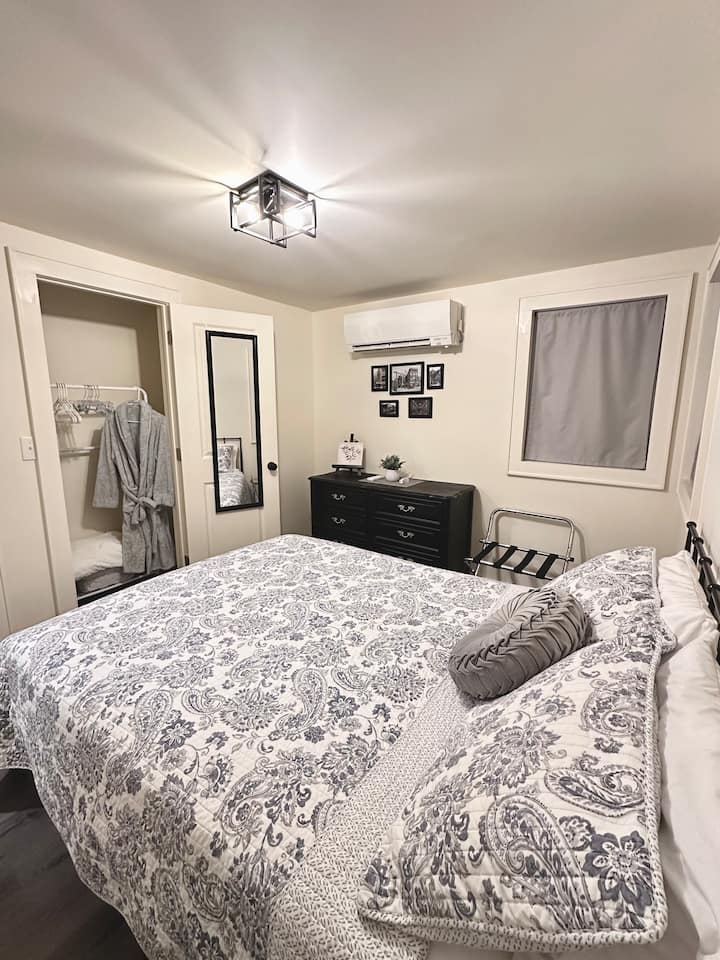 Relax and recharge in this calming retreat. Enjoy a cozy queen bed, soft lighting, dresser, extra blankets, and bedside tables. In-room heat/AC keeps you comfortable, plus a closet with robe and hangers. Book your peaceful escape today!