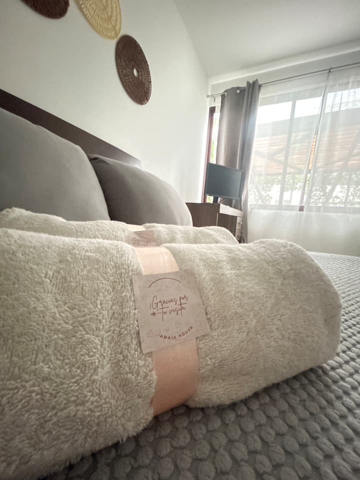 Gezellige en elegante hoofdslaapkamer met een comfortabel bed, vezeldetails en een vleugje premium gastvrijheid voor een onvergetelijk verblijf.