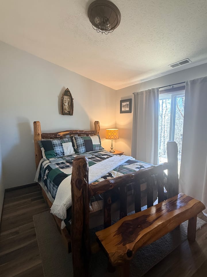 Chambre avec lit Queen Size, banc, table de chevet et placard