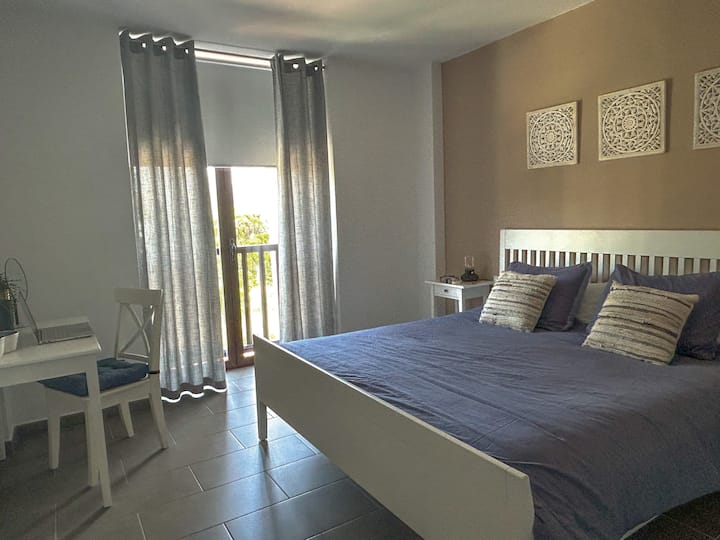 חדר שינה ראשי עם מיטת קווין סייז בגודל 180x200, שולחן איפור/סביבת עבודה והרבה מקום לאחסון בגדים ומזוודות. חדר רחצה צמוד.