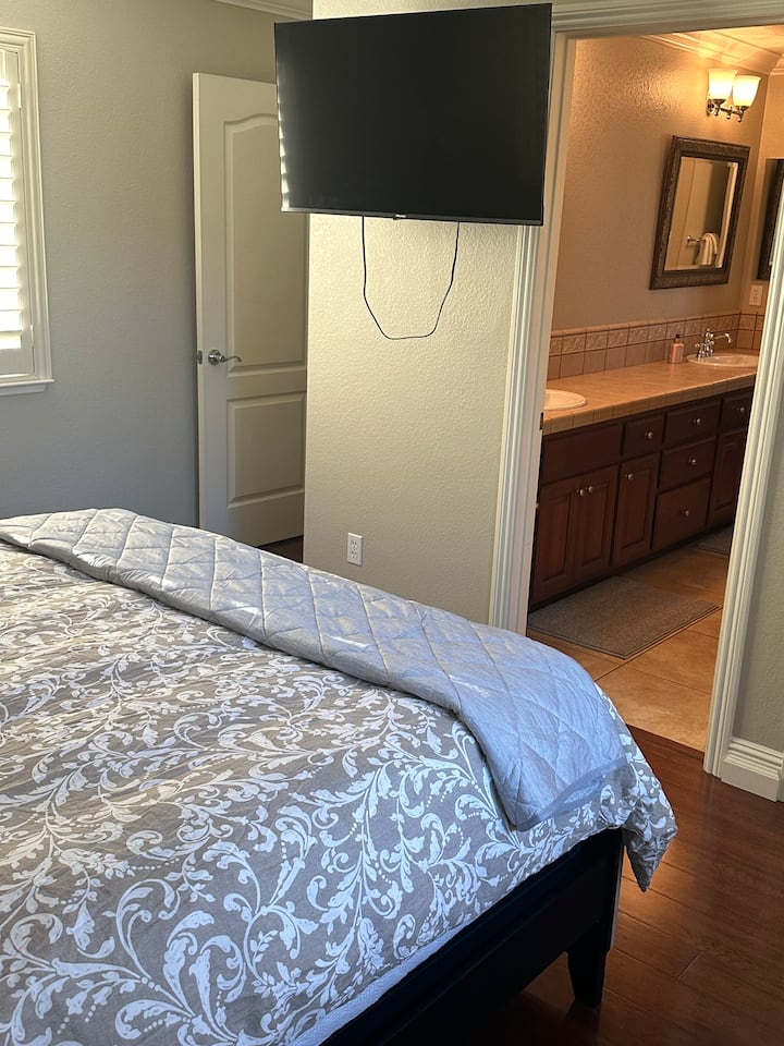 חדר שינה מפואר עם חדר רחצה פרטי ופריטים חיוניים. מרווח ונקי, עם מראה גדולה ואזור אסלה נוח. שפע של אור שמש ואווירה נעימה. טלוויזיה חכמה 45 אינץ' לבידור. מושלם למנוחה.
