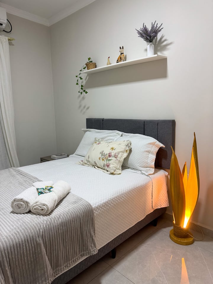 Dormitorio con cama doble con muelles de bolsillo, lámpara ecológica y aire acondicionado dividido.