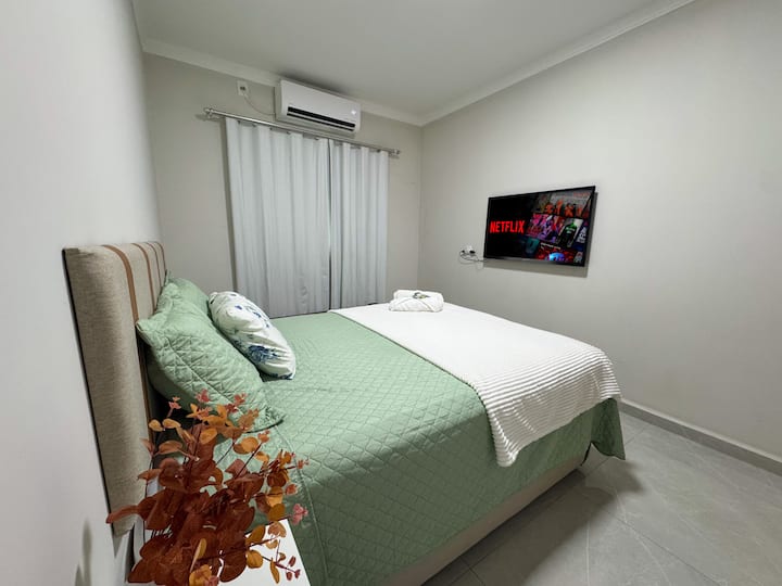 Amplia habitación con ventana opaca, cama tamaño queen con muelles ensacados, aire acondicionado dividido y TV.