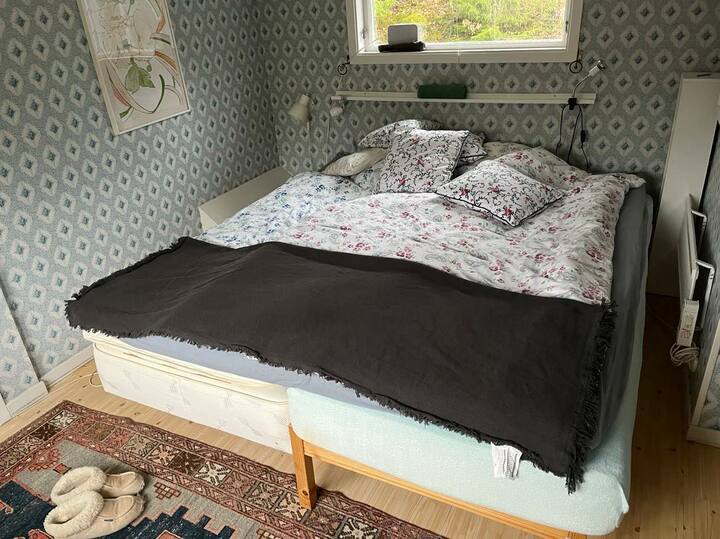 يوجد في غرفة النوم الرئيسية سريران. من هناك، تنظر إلى حافة الغابة في الخارج.