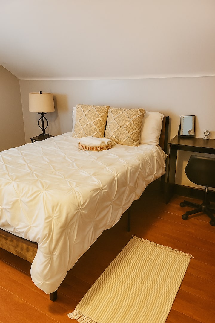 Svijetla soba s kosim stropom, udobnim krevetom i elegantnim neutralnim tonovima