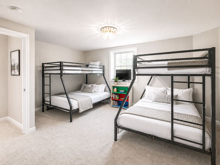 Une chambre amusante pour une soirée pyjama pour les enfants, avec des lits superposés, beaucoup d'espace pour dormir et jouer, ainsi qu'un dressing avec des casiers individuels pour chaque enfant.