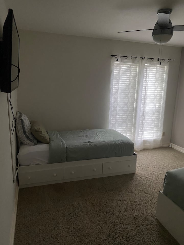 La camera da letto n. 3 ha due letti singoli posizionati uno di fronte all'altro, creando una disposizione funzionale. Ogni letto dispone di lenzuola confortevoli, mentre una TV montata offre intrattenimento, rendendolo ideale per fratelli, amici o familiari che condividono lo spazio.