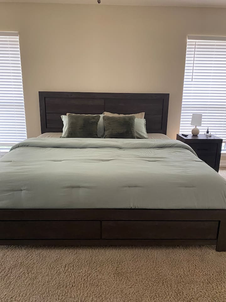 Nella camera da letto principale, un ampio letto king-size combina comfort e lusso con un morbido materasso e biancheria da letto di alta qualità. La testiera imbottita e i cuscini decorativi aggiungono intimità, mentre gli eleganti comodini con lampade creano un'atmosfera calda per notti riposanti.