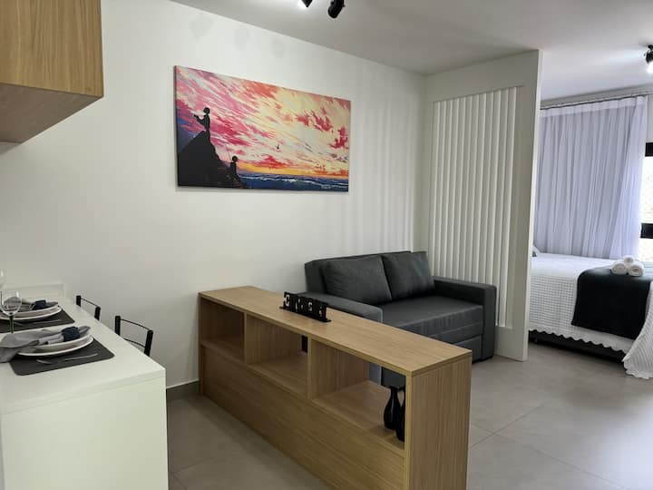 ห้องนั่งเล่นพร้อมโซฟา ชั้นวางของ และเคาน์เตอร์ 3 ที่นั่ง