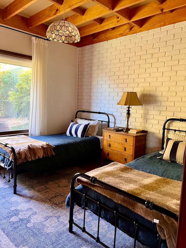 שתי מיטות יחיד קינג סייז, מצעים, כריות ושטיחים נוספים במידת הצורך. שידת מגירות וארון בגדים גדול. יש לחסום את התריסים מאחורי וילונות שקופים למצעים.
