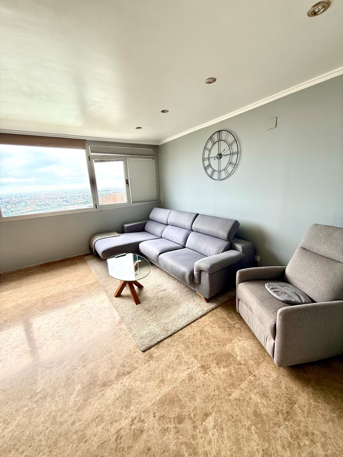 El salón es luminoso y cómodo, con grandes ventanales de la Ciudad de las Artes y las Ciencias. Tiene un gran sofá, una silla reclinable, un televisor de 85 pulgadas, juegos de mesa, una mesa pequeña para tomar algo y una mesa de comedor, perfecta para relajarse o pasar una noche tranquila.