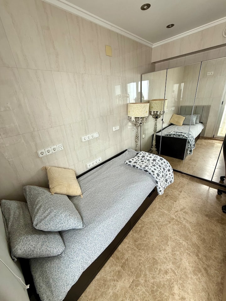 غرفة مريحة بسرير واحد يمتد إلى سرير مزدوج، مثالية لضيف أو ضيفين. مشرق وبسيط، مع إطلالات جميلة على المدينة.