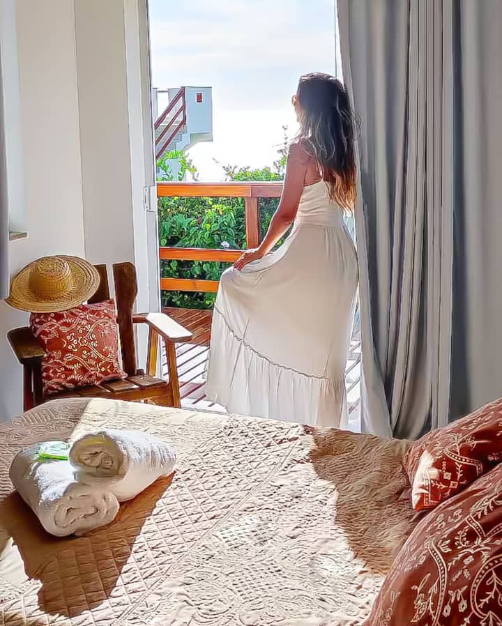 Quarto suíte com deck privativo com vista para o mar e montanhas do Pontal do Atalaia.