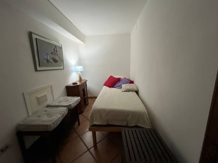 Roh pozostávajúci z jednolôžka a nočného stolíka . Nie sú tam žiadne dvere . 