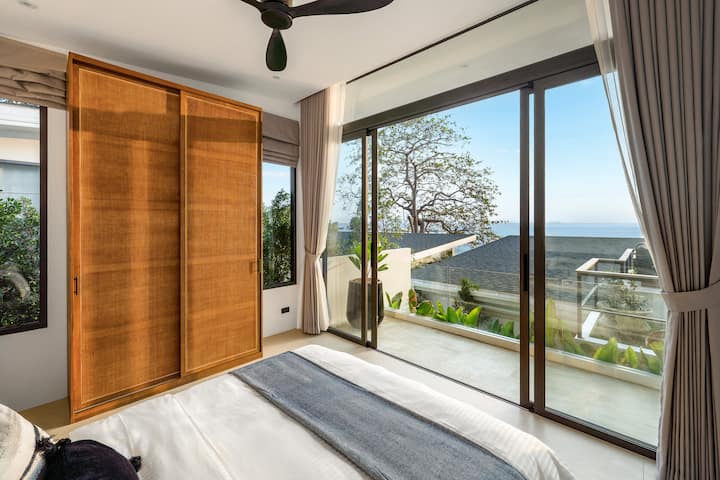 海岸沿いの穏やか–無限のブルーのテラスの直接の眺めを楽しめる、落ち着いたクイーンベッドルームのエスケープ。