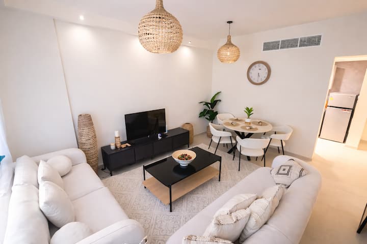 Amplia sala de estar con mucha luz natural y acabados contemporáneos. Ideal tanto para veladas relajantes como para recibir a invitados. Un espacio acogedor que se siente como en casa.