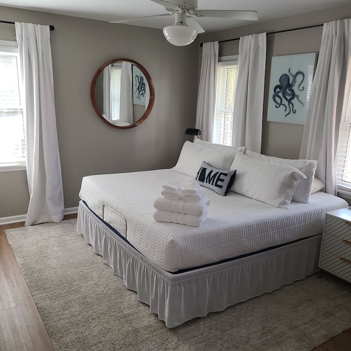 Slabá primárna spálňa s manželskou posteľou veľkosti King a nastaviteľným rámom postele