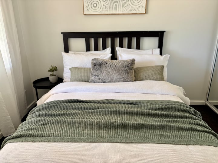 La comodidad se une a la conveniencia en la habitación verde: cama doble, amplio espacio de almacenamiento y una vista de la terraza a solo unos pasos de la cocina.