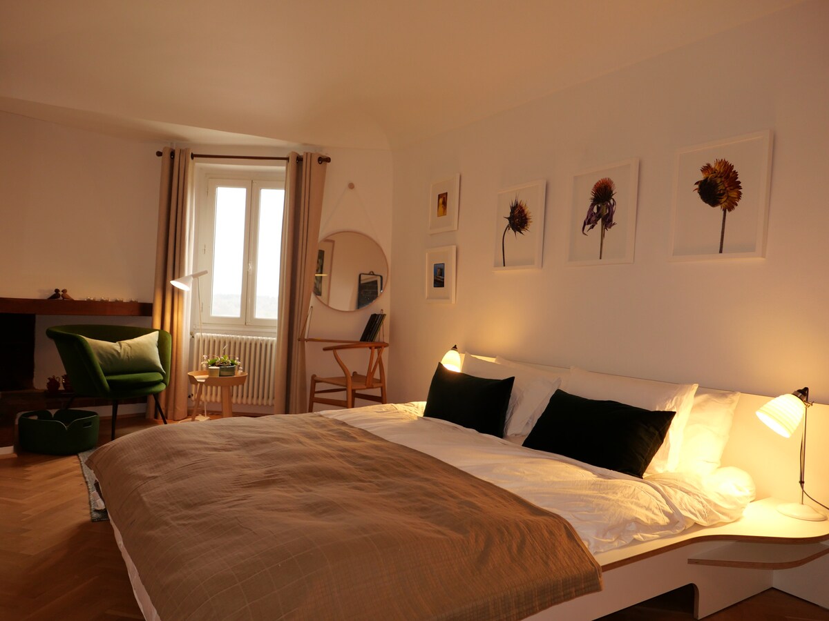 El segundo dormitorio está en el segundo nivel y tiene una cama tamaño king, piso de parque y un baño privado (baño 2). También hay una silla cómoda para leer o simplemente mirar la vista.