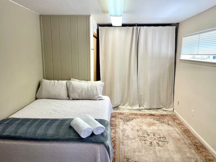 这是洗衣间/泥房，改造成卧室。
请注意，洗衣机和烘干机在窗帘后面。
水泵在这个房间里。