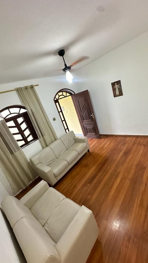 Sala con sofás de 2 y 3 plazas, TV y ventilador de techo.