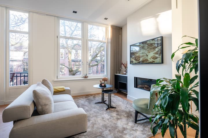 เลานจ์สบายๆ ที่มีแสงธรรมชาติและเตาผิงสไตล์โมเดิร์น