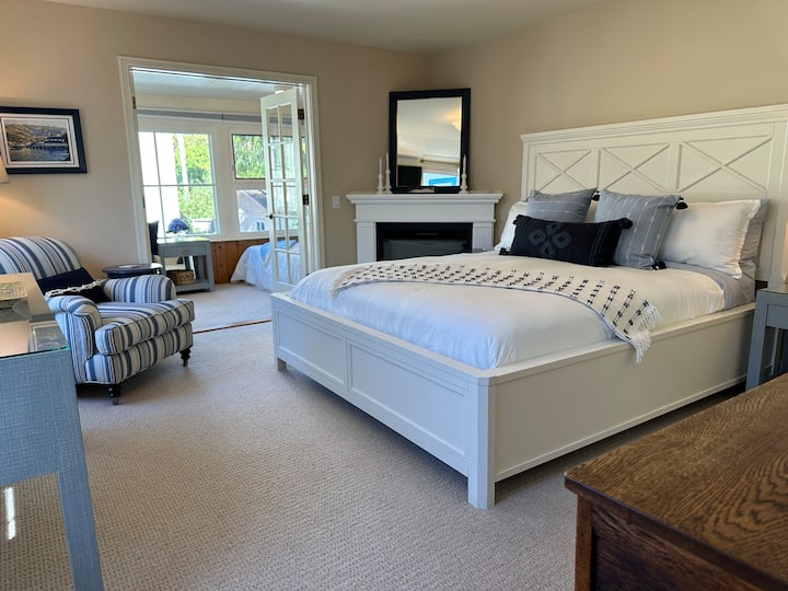 The King Suite is upstairs and accommodates 3 people with one Cal king bed plus a twin through the double French doors in separate interior sunroom.  Cozy electric corner fireplace.