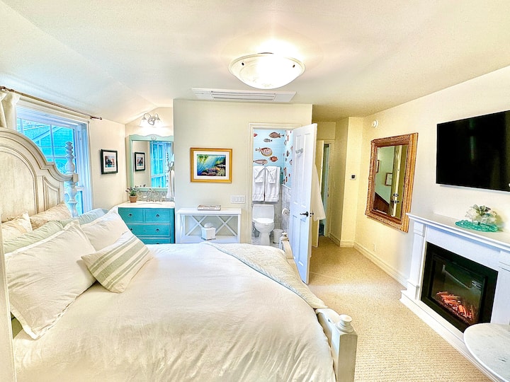 The Queen Suite is upstairs and features a queen size bed plus a separate twin bed through glass French doors inside the sunroom. Plenty of storage for clothes plus an ensuite bathroom with walk-in shower.