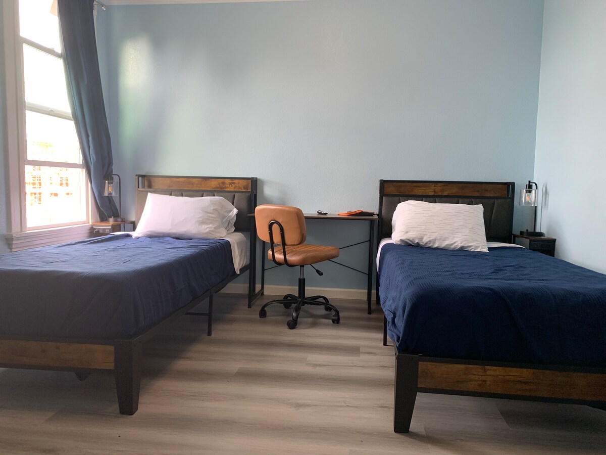  2 ორსაწოლიანი საწოლი. XL საწოლების გაზომვები 38 სმ სიგანისა და 80 სმ სიგრძისაა, ის იტევს 6 სმ და მეტ ზრდასრულს. Ამ ოთახში არის 2 სამუშაო სადგური. Ტუმბოს აქვს 110V გამოსასვლელები და უსბ დამუხტვის კომფორტული საშუალებები თქვენი მოწყობილობების დასამუხტად. 