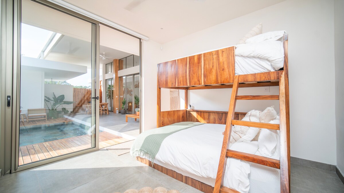 El dormitorio cuenta con una litera con una cama tamaño queen en la parte inferior y dos camas individuales en la parte superior. Incluye un escritorio para el trabajo, un amplio espacio en el armario para colgar o doblar la ropa y un baño privado. El diseño de todas las suites cuenta con una ducha exterior cerrada con techo de catedral.