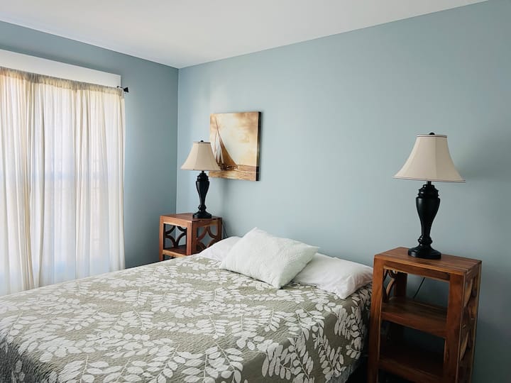 غرفة نوم على اليمين بسرير مقاس كوين مع خزانة كبيرة 