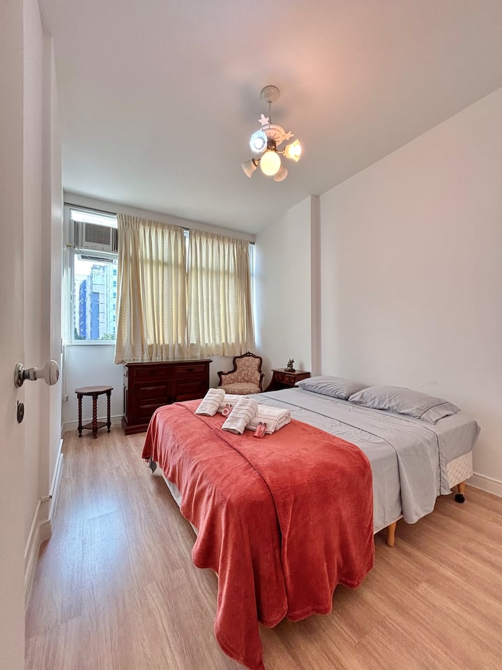 Double bedroom with wardrobe, dresser and air conditioning. Reading armchair. 