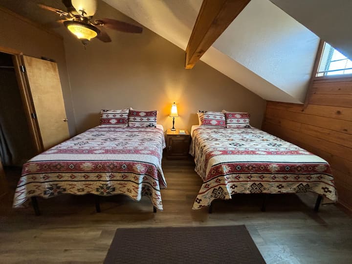 Two brand new queen beds in upstairs bedroom with smart tv and upstairs bathroom (bedroom overlooks living room/kitchen area~ no privacy walls) 