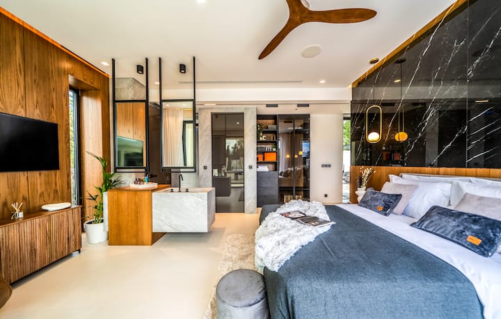 Ground Floor - Bedroom 1 with queen bed, ensuite bathroom, Grohe hydromassage shower, and direct pool access.