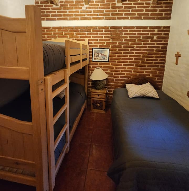 Warm and functional room, ideal for families or companions. It has a double bunk bed, double bed, wardrobe and dresser, offering a comfortable and well-distributed space to rest peacefully after a day in the forest.