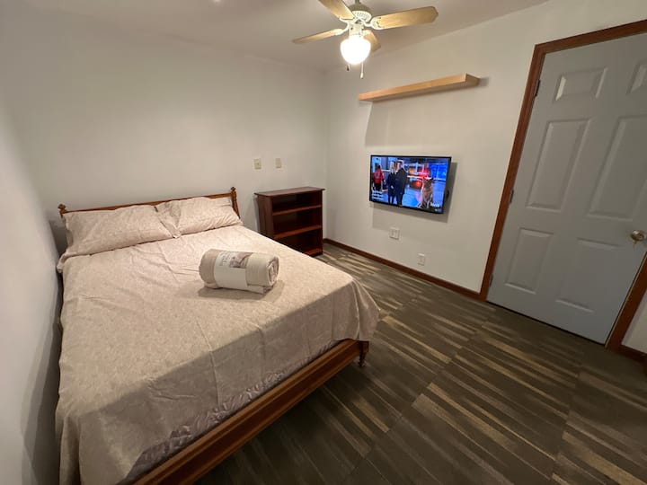 כאן תישנו. טלוויזיה חכמה של Samsung בגודל 43 אינץ' עם ערוצי South Bend ו-Chicago OTA, שידה עם שלושה מגירות, מדף ספרים, מאוורר תקרה, אפשרויות תאורה כפולות. 