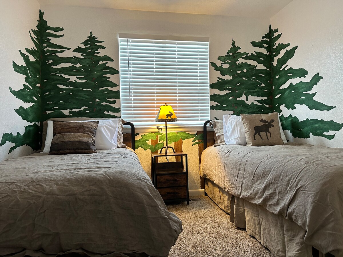 تحتوي غرفة النوم 2 على سريرين متماثلين وأعمال فنية ممتعة على شجرة الصنوبر على الحائط