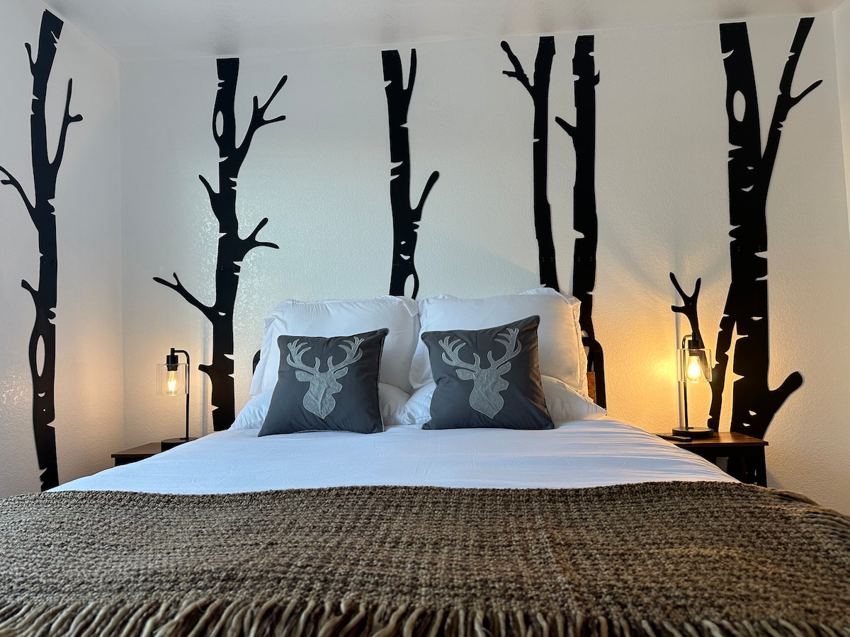 تحتوي غرفة النوم رقم3 على سرير بحجم كوين مع ديكور شجرة أسبن وتلفزيون ذكي