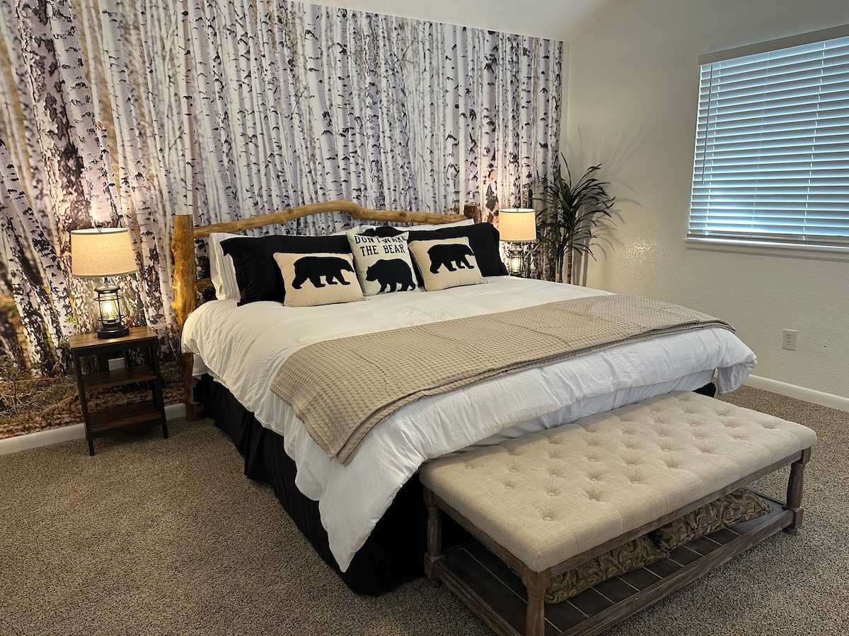 غرفة نوم رئيسية بسرير كينج وجدار عملاق من أشجار الحور الرجراج لتوفير بيئة مهدئة 