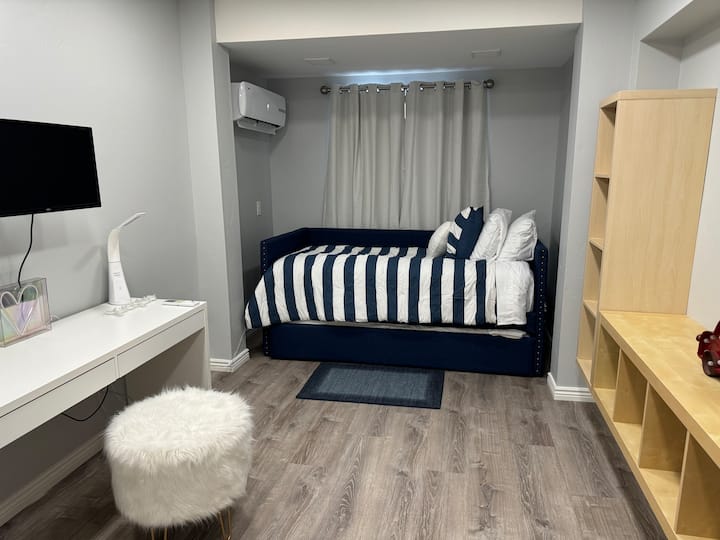 Slaapkamer met een bureau en een monitor om wat werk te doen heeft ook een uitschuifbed onder het dagbed dat gemakkelijk uit te trekken is en wordt gebruikt voor een andere gast 