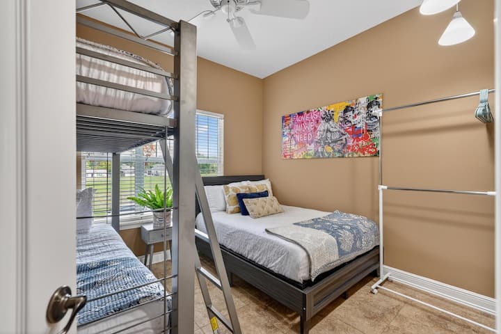 Este quarto versátil é perfeito para famílias ou grupos, com uma cama de casal e um beliche de solteiro. Com arte de rua vibrante, um ventilador de teto refrescante e um cabideiro prático, é um espaço iluminado e funcional para todos.