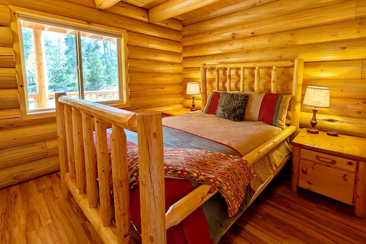 חדר שינה נוח בקומה הראשית עם מיטת עץ זוגית מותאמת אישית ותריסים