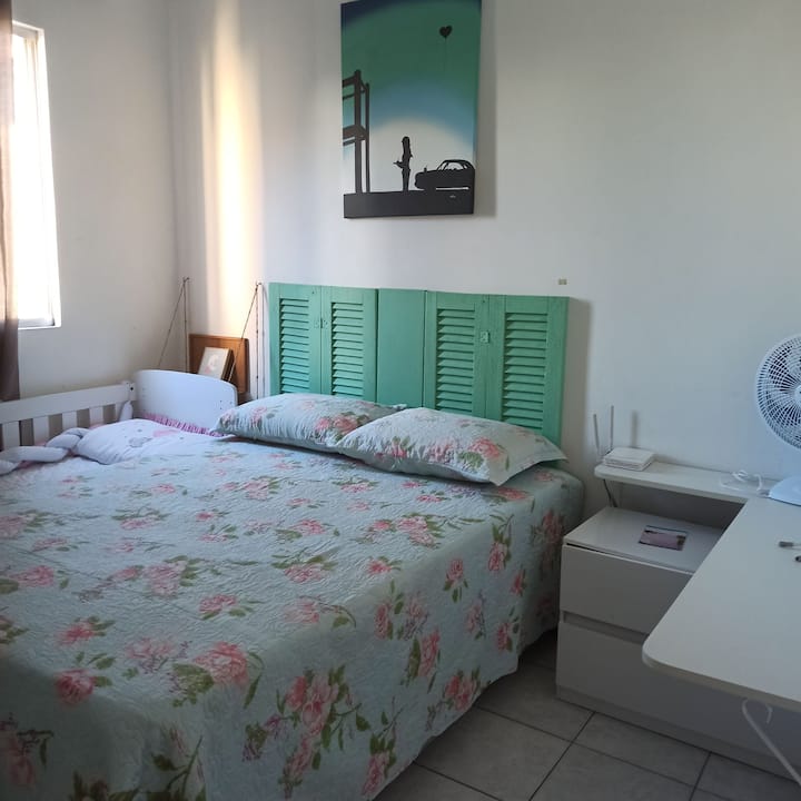 Habitación con una cama doble, una cuna y una pantalla para niños para protección en las ventanas.