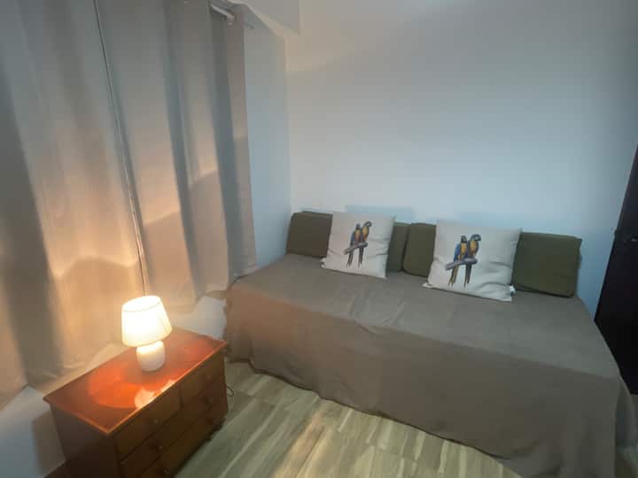 ห้องพักมีเตียงเดี่ยวสองเตียง พัดลมเพดาน และม่านบังแสง