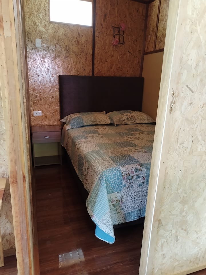 Una habitación pequeña, cómoda y acogedora para dos personas.