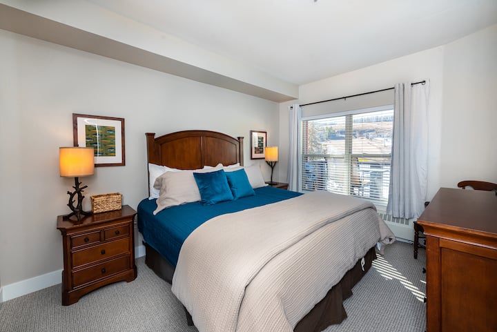 Relax in the “Fish Theme” bedroom featuring a king bed, warm wood furniture, soft lamps, and bright natural light. Clean, calm, and inviting with direct access to the bathroom and plenty of space to settle in.