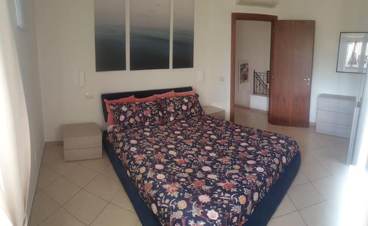 غرفة نوم بسرير مزدوج 160 × 200 سم وخزانة ملابس بثلاثة أبواب وصندوق أدراج وطاولات بجانب السرير. وسائد وبطانيات إضافية. 